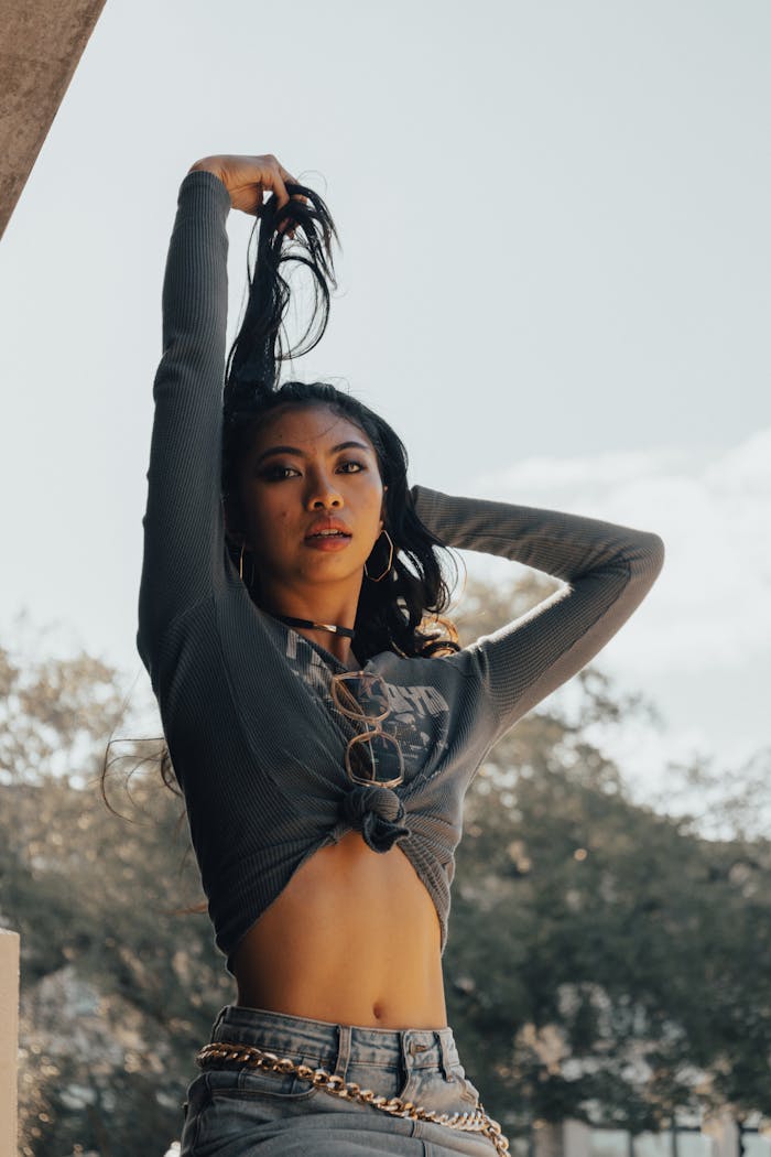 Stylish woman posing outdoors in fashionable attire under natural light.